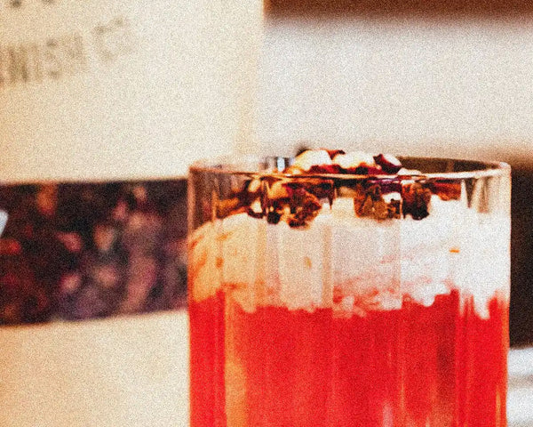 Valentine's Day Rosy Reverie cocktail with edible rose petals and dehydrated orange slices garnish