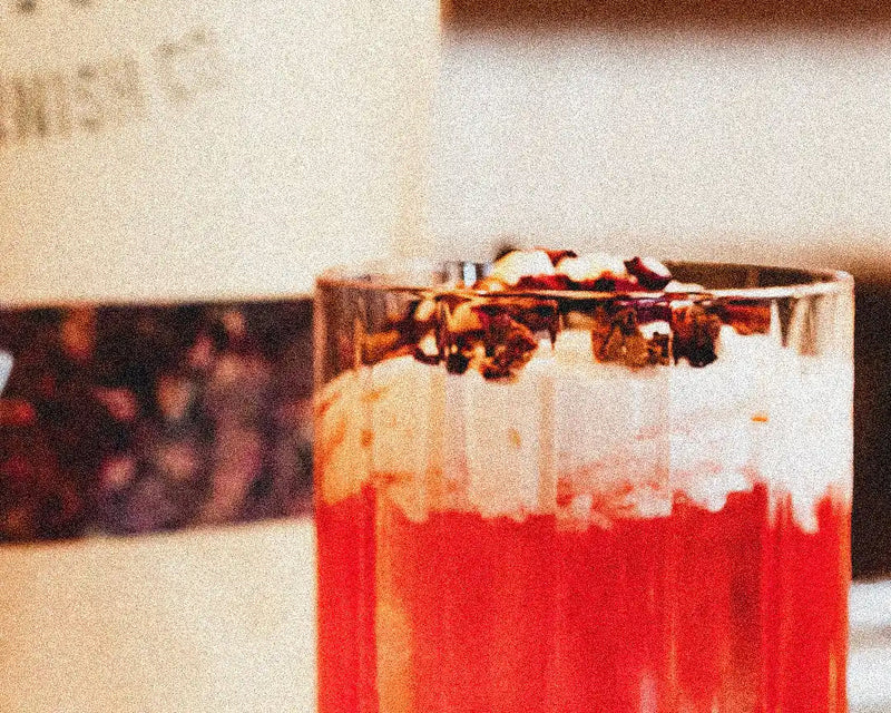 Valentine's Day Rosy Reverie cocktail with edible rose petals and dehydrated orange slices garnish