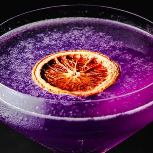 Spooky Halloween punch recipe with dehydrated blood orange slices and edible glitter sugar