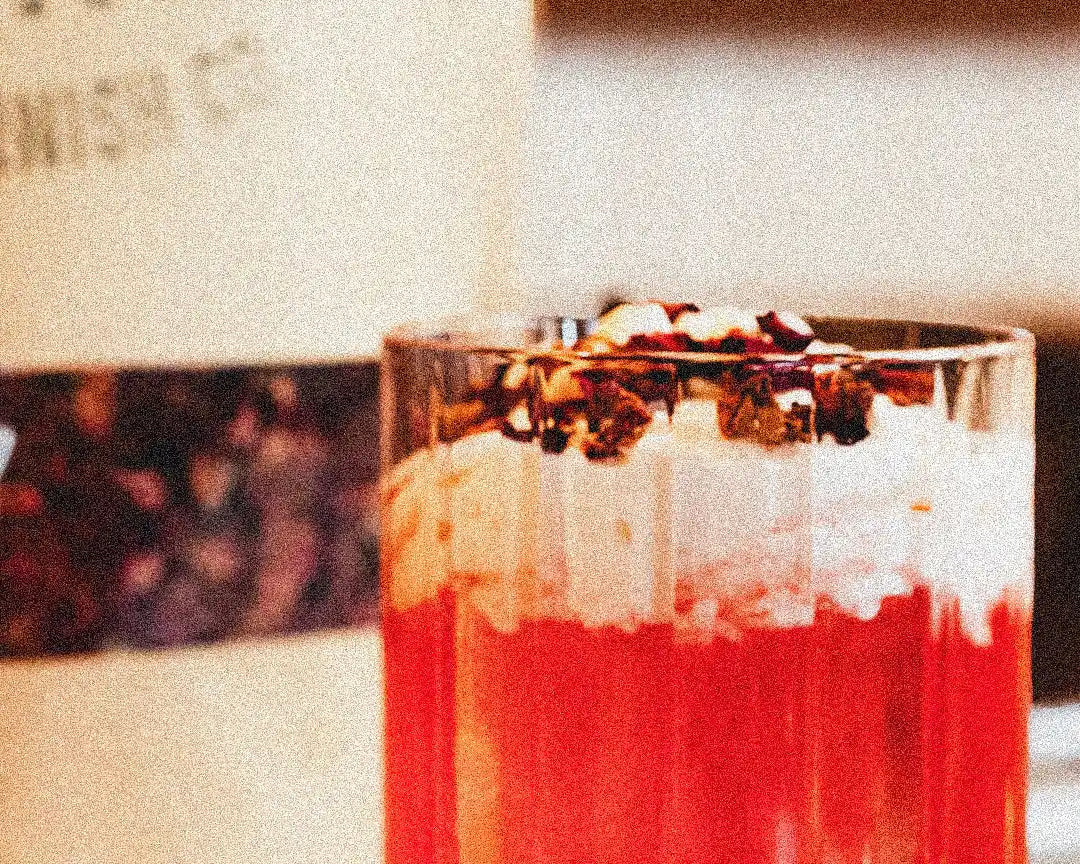 Valentine's Day Rosy Reverie cocktail with edible rose petals and dehydrated orange slices garnish